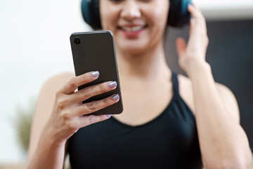 Young Woman Engaging in Wellness Activity with Smartphone and Headphones, Promoting Healthy Lifestyle and Mental Wellbeing