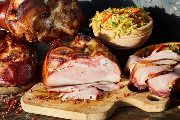 A large piece of oven-baked meat, cut into slices, lies surrounded by various pickles. Meat production