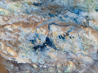 View from above, stunning aerial view of Námafjall Geothermal Area also known as Hverir with smoking fumaroles and boiling mud pots, surrounded by sulphur crystals of many different colours, Iceland.