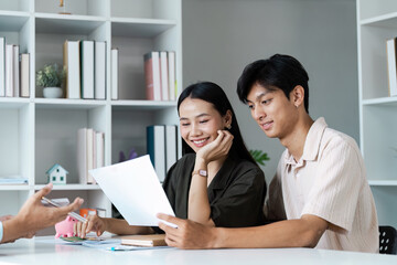 Happy Couple Engaged in Financial Planning at Home, Reviewing Documents and Discussing Future Goals