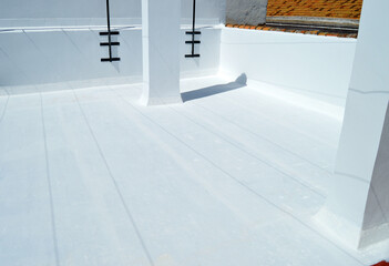 Terrace painted white to reduce the heat of summer sun. Waterproofing the house terrace with white rubber paint. Completely white building roof to combat high temperatures caused by climate change. 