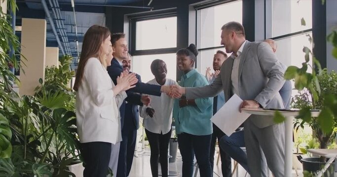 Boss shaking hands with an employee during an office meeting with the team. Agreement, collaboration, and partnership, fostering a strong and cooperative work environment within the group.