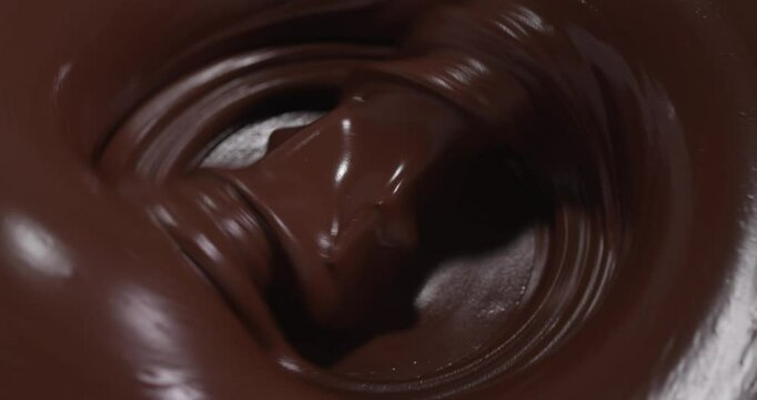 Rich, glossy texture of swirling melted chocolate, giving a sense of indulgence and luxury suited for confectionery themes