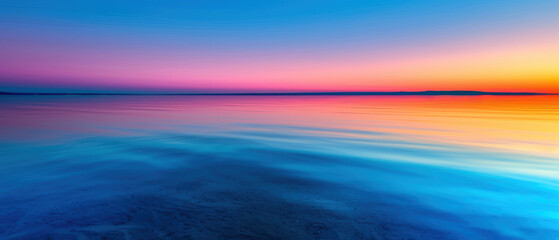 A beautiful blue ocean with a pink and purple sky in the background