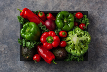 assorted red and green vegetables tomatoes, bell peppers, kale avocado
