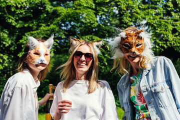 Three young adult beautiful woman girls friends enjoy have fun wearing animal mask laughing at picnic party city park green garden at sunny day. Female person friendship summer outdoors celebration