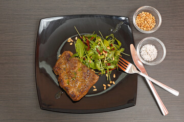 Grilled Steak and Arugula Salad With Pignoli Nuts Served at Dark Plate Top View