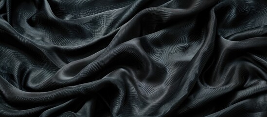 Obraz premium Detailed view of creases in a piece of black silk fabric, showcasing intricate texture and pattern with copy space image.