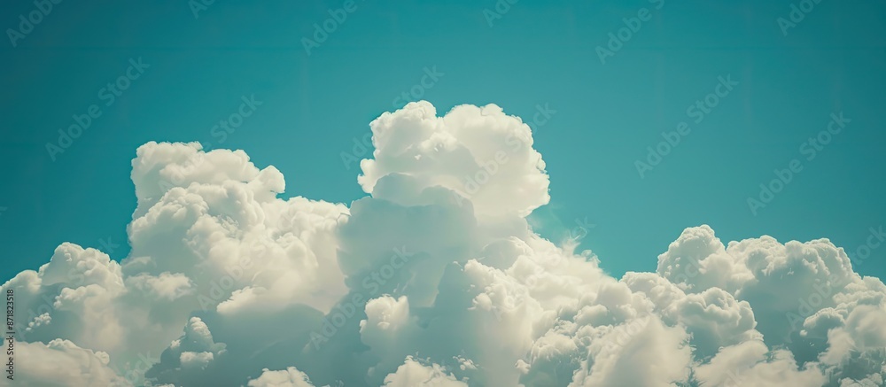 Poster Clouds on a blue sky background create a serene nature scene in this copy space image.