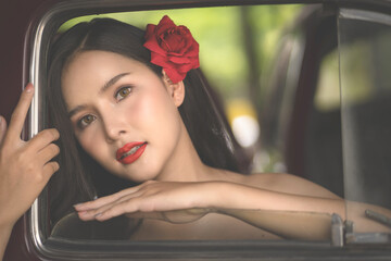 Beautiful portrait of an Asian female. A pretty woman wearing a red sash and green loincloth a traditional Thai dress costume. Asian tourists dress to blend in ancient Thai culture.