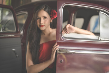 Beautiful portrait of an Asian female. A pretty woman wearing a red sash and green loincloth a traditional Thai dress costume. Asian tourists dress to blend in ancient Thai culture.
