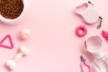 Frame of pet supplies arranged on a vibrant pink background. Flat lay bowl of dry food, pet...