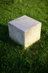 Cubo de granito en suelo de hierba de parque