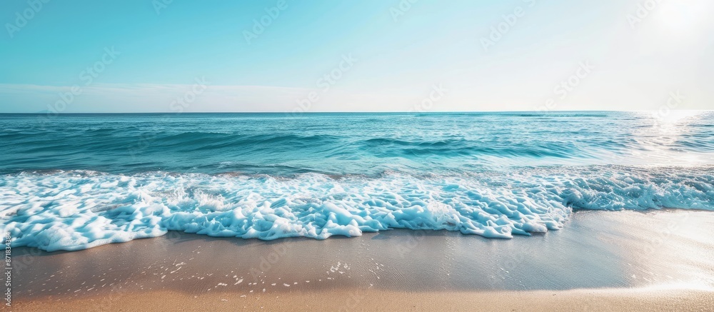 Poster Ocean waves gently lapping the sandy shore create a calming scene with a breathtaking view of the horizon and a clear blue sky in the background with copy space image.