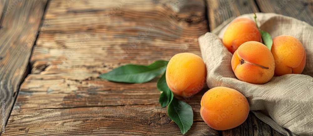 Poster close-up of ripe apricots on a wooden table with a napkin, copy space image.
