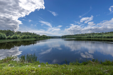 A calm lake with a blue sky in the background