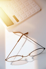 Desk with laptop, eye glasses, earphone, pen and a cup of coffee. Top view with copy space.