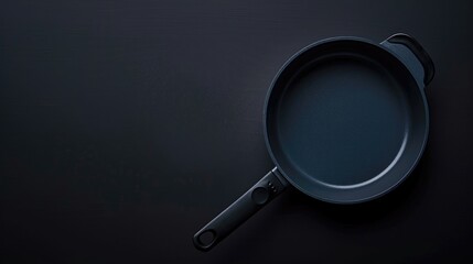 New Teflon saucepan on black backdrop empty and non stick for aerial perspective