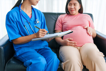 Asian female doctor and nurse perform an ultrasound on a pregnant woman, using a stethoscope and medical equipment, ensuring her health and preparing for a successful birth.