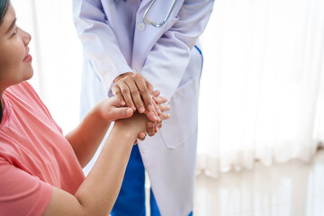 Asian female doctor nurse encouragement to a pregnant woman on a sofa, using ultrasound and stethoscope, addressing medical conditions like edema, varicose veins, and pregnancy-induced hypertension.