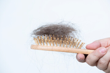 woman holds clump hair after brushing, stress-related hair loss, wooden comb, brush in female hand, health, causes, symptoms and treatment alopecia, hormonal imbalance