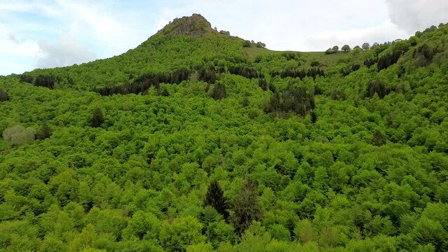 Aerial view of the Alpine mountain peaks on the border of Italy and Switzerland. The drone flies between green slopes and dramatic clouds. Trekking and tourism in the mountains. Green Paneth. Oxygen. 