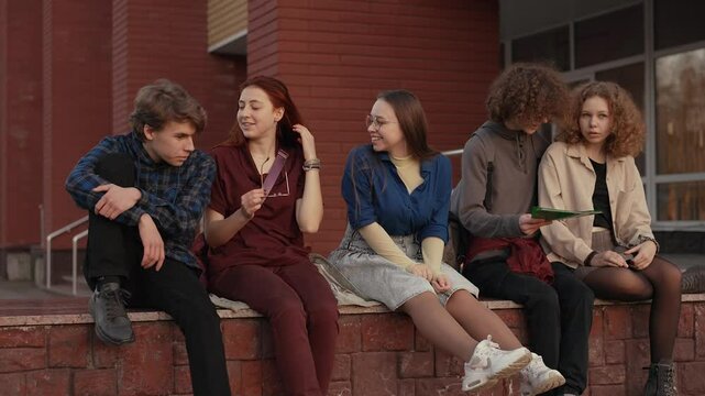 Happy students on the parapet near the school