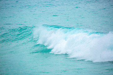 Waves on the sea. Water background, blue sea water. Beautiful texture of sun glare on water and sea foam.