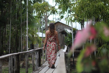 Naklejka premium mulher caminhando em palafitas em hotel de selva, no Amazonas 
