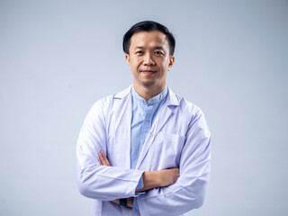 Asian male doctor in a white coat with arms crossed, exuding confidence and professionalism. The...