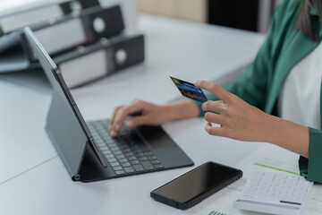 mage of a young Asian businesswoman holding a credit card.