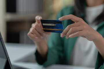 mage of a young Asian businesswoman holding a credit card.