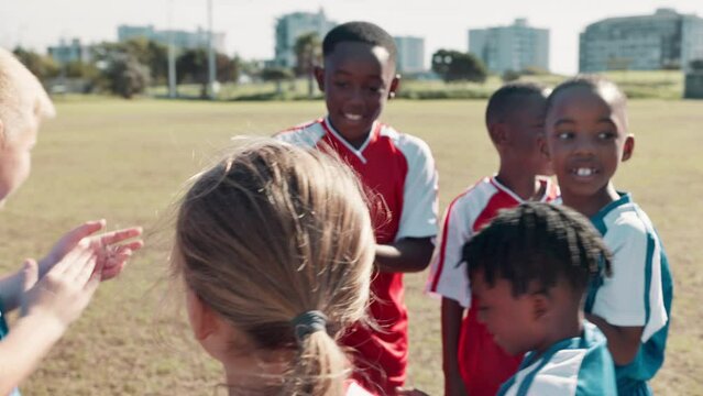 Coach, children and hands stack for soccer, motivation and game for sport with diversity on field. Man, football and teamwork in scrum for support, synergy or link with cheers for solidarity on pitch