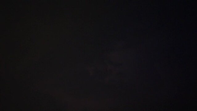 Lightning flashes through dark storm clouds. Black clouds before the thunderstorm. Perfect super slow motion footage, loop able b roll video.