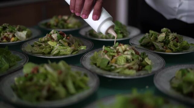 chef adereza muchas ensaladas ordenadas en una mesa de restaurant antes de un gran banquete