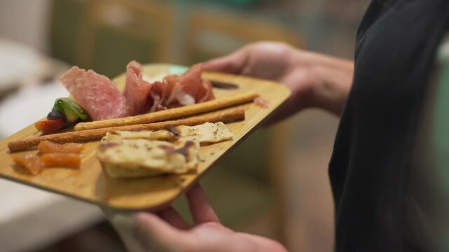 persona lle a su mesa un plato de fiambres y pan