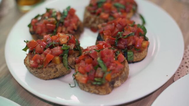 delicioso pan italiano con un topping de tomates con albahaca colocados sobre un plato blanco