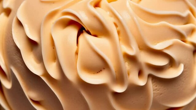 Video. Cappuccino flavored ice cream is a full frame background detail. Close-up of beige surface texture of cappuccino ice cream, top view	