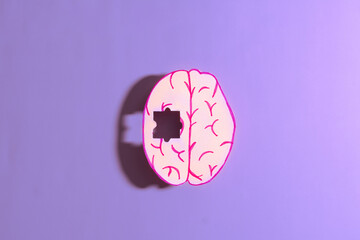 Human brain anatomy missing a piece of jigsaw puzzle on purple background. Concept of Memory loss,...