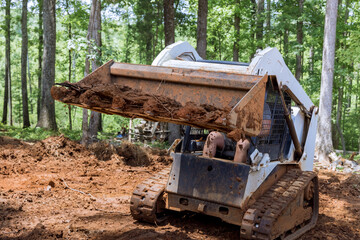 Tractor is leveling ground at earthmoving in cleaning backyard construction work