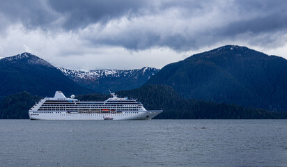 Large cruise ship in front of mountains during a overcast day in Sitka Alaska 