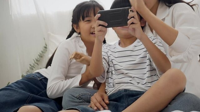 Mother son and daughter selfie with mobile on bed