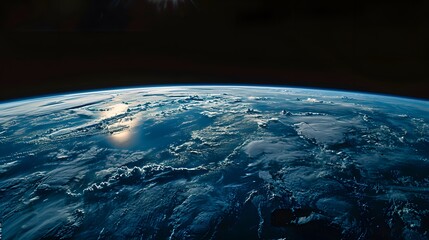 Fototapeta premium A panoramic view of the Earth from space, with sunlight casting long shadows over its blue surface and black sky background. The scene conveys vastness and beauty of our home world.