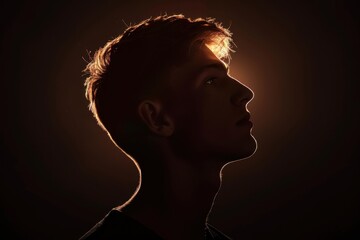 Silhouette of the head and shoulders of an attractive young man in front of a black background, backlit, studio portrait Generative AI