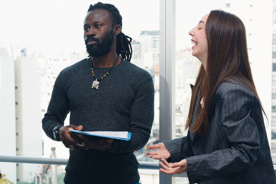 Woman and man coworkers in the office looking to the side with comical expression