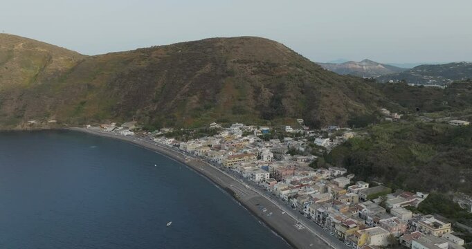 Aerial view of coastal town with mountain backdrop and water, Lipari, Aeolian Islands, Italy.