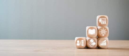 Wooden blocks with icons symbolizing capacity building, education, growth, and development on a...