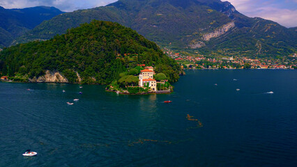 Fototapeta premium Aerial view of the luxury Villa Balbianello with terraced gardens, on the rocky wooded peninsula of Lavedo on Lake Como, panorama, picturesque residence. Green Planet. Nature. Lenno Italy 12.07.2024