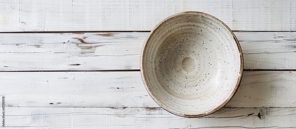 Aufkleber top-down view of an empty ceramic bowl on a white wooden table, with room for adding text or a copy 