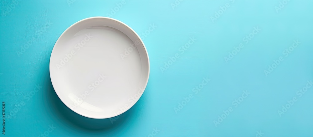 Leinwandbilder top view of an empty white plate on a blue background table with copy space image.